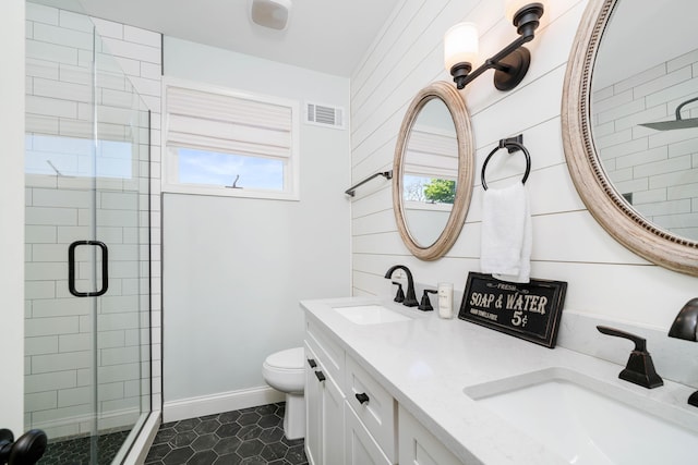 bathroom featuring a shower with shower door, toilet, vanity, and wood walls