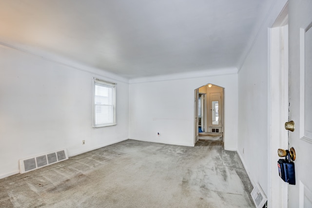 carpeted empty room featuring crown molding