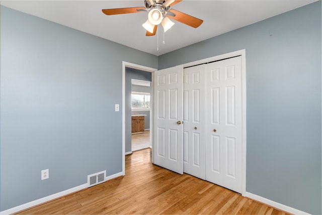 unfurnished bedroom with ceiling fan, a closet, and light wood-type flooring