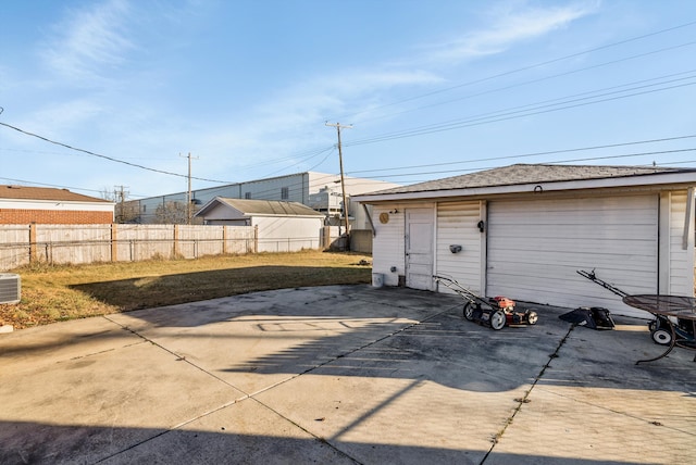 view of patio / terrace with a garage and an outbuilding