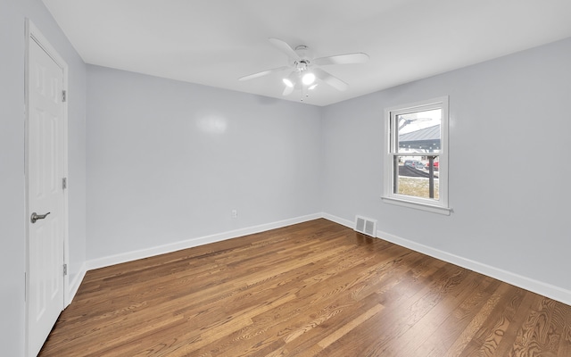 unfurnished room with a ceiling fan, baseboards, visible vents, and wood finished floors