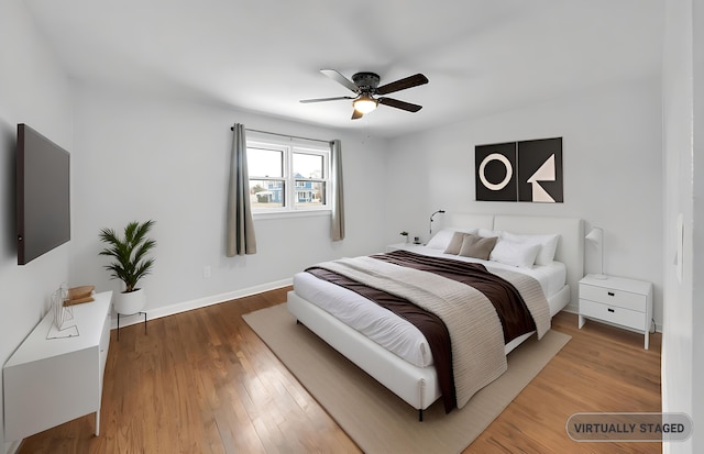 bedroom with wood finished floors, a ceiling fan, and baseboards