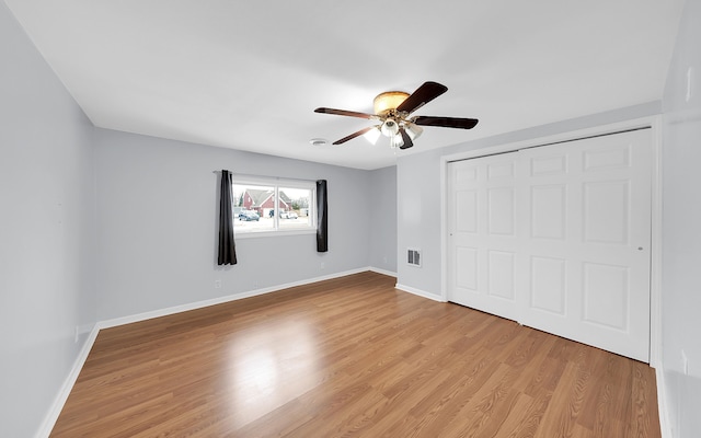 unfurnished bedroom featuring baseboards, visible vents, a ceiling fan, light wood-type flooring, and a closet