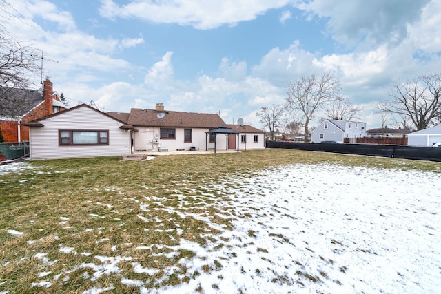 back of house featuring a gazebo, a lawn, and fence