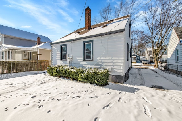 view of snow covered back of property