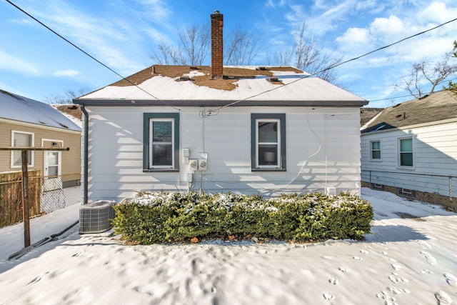 snow covered property with cooling unit