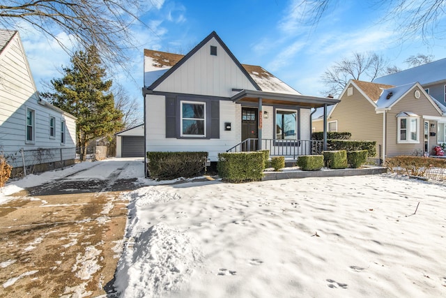 bungalow-style house featuring a garage, an outdoor structure, and covered porch