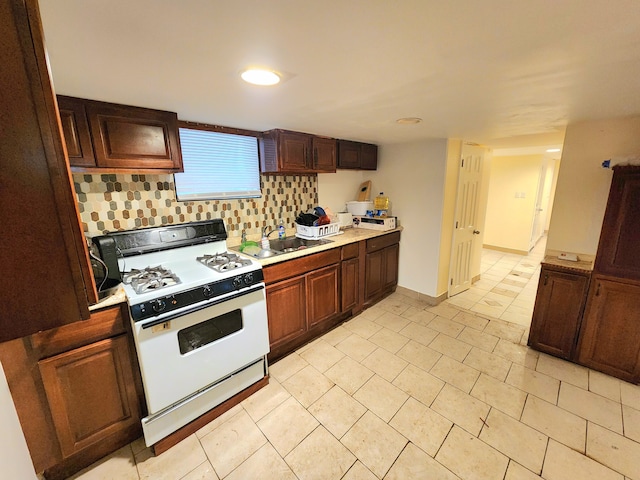 kitchen with sink, backsplash, and white gas stove