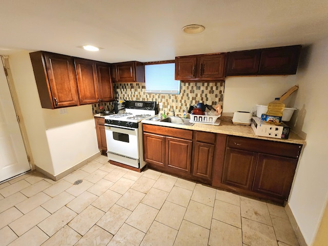 kitchen featuring decorative backsplash, sink, and gas range gas stove