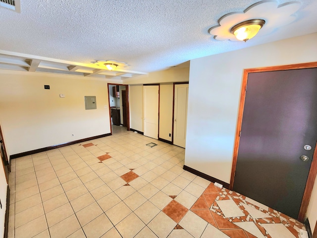 tiled empty room with electric panel and a textured ceiling