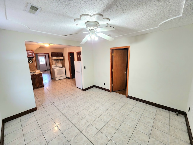 tiled empty room featuring ceiling fan and a textured ceiling