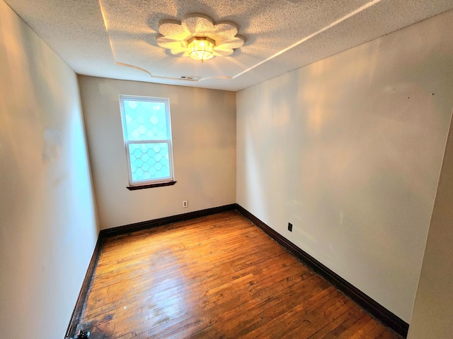 empty room featuring hardwood / wood-style flooring and a textured ceiling