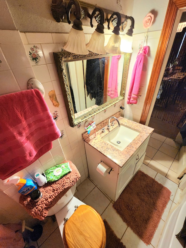 bathroom featuring tile patterned floors, toilet, tile walls, and vanity