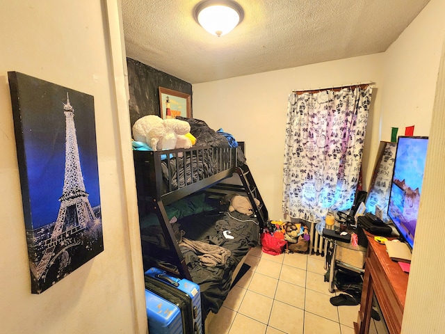 tiled bedroom with a textured ceiling