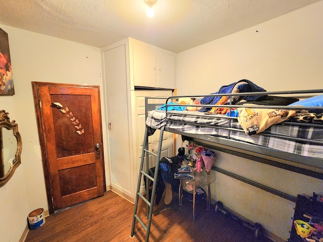 bedroom with hardwood / wood-style flooring and a textured ceiling