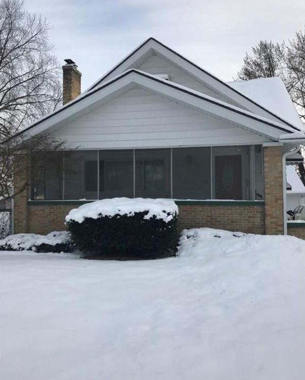 view of snowy exterior with a sunroom