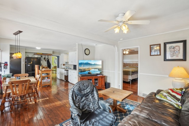 living room with dark wood-type flooring and ceiling fan