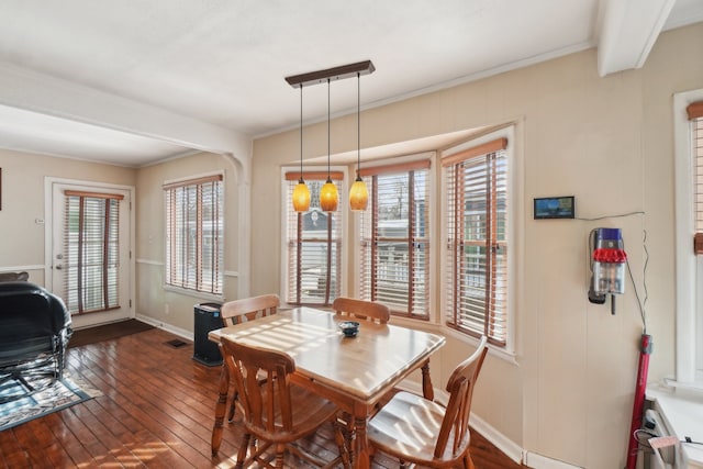 dining area with crown molding, plenty of natural light, and dark hardwood / wood-style floors