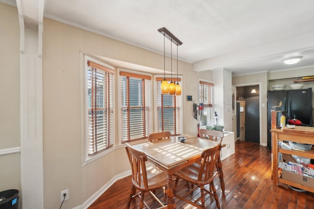 dining space with dark hardwood / wood-style flooring and crown molding