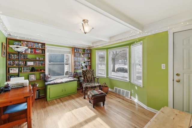 sitting room featuring beam ceiling and light wood-type flooring