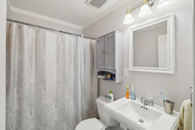 bathroom featuring ornamental molding, toilet, and sink