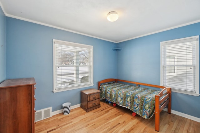 bedroom featuring ornamental molding and light hardwood / wood-style flooring