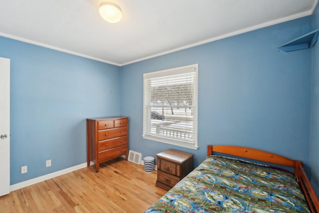 bedroom featuring crown molding and light wood-type flooring