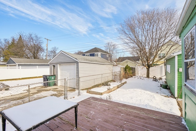 snow covered deck featuring a garage and an outdoor structure