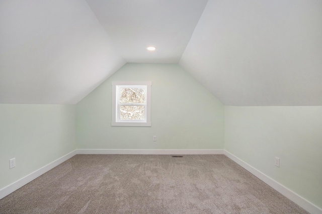 bonus room with light carpet and lofted ceiling