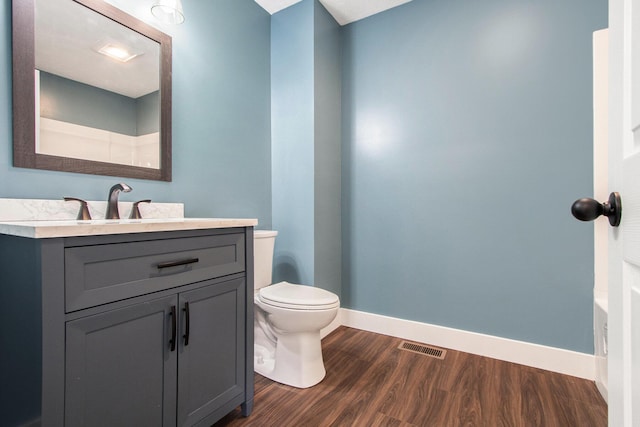 bathroom with hardwood / wood-style flooring, toilet, and vanity