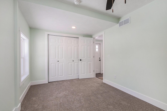 unfurnished bedroom with a closet, ceiling fan, and carpet