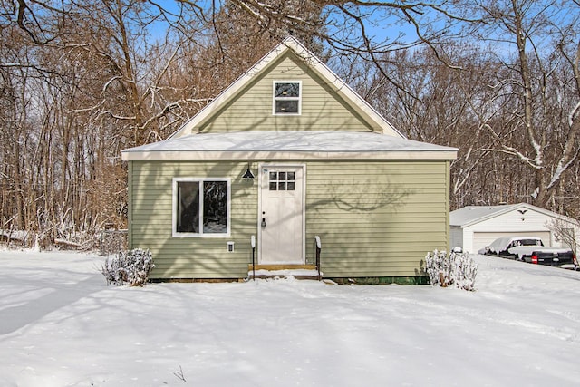 snow covered structure with a garage