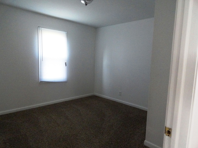 empty room with a healthy amount of sunlight and dark carpet