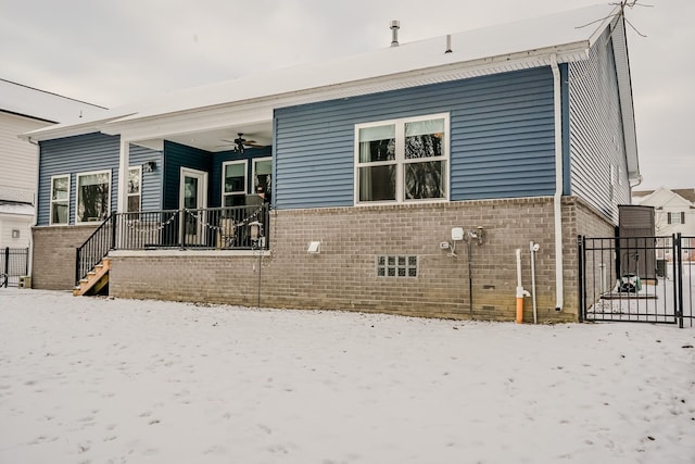 snow covered rear of property with a porch and ceiling fan