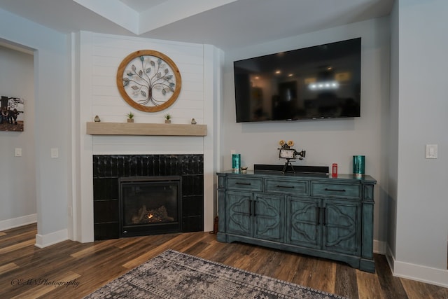 living room with dark wood-type flooring and a fireplace