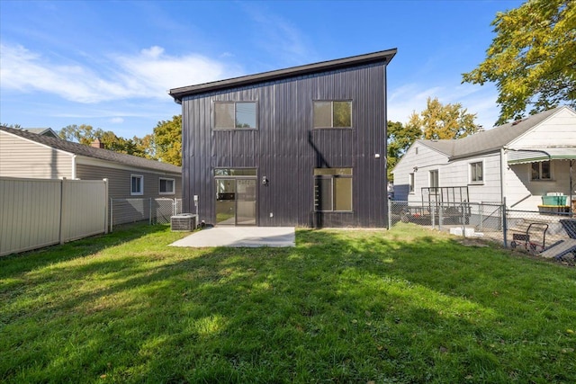 rear view of property with central air condition unit, a patio, and a lawn