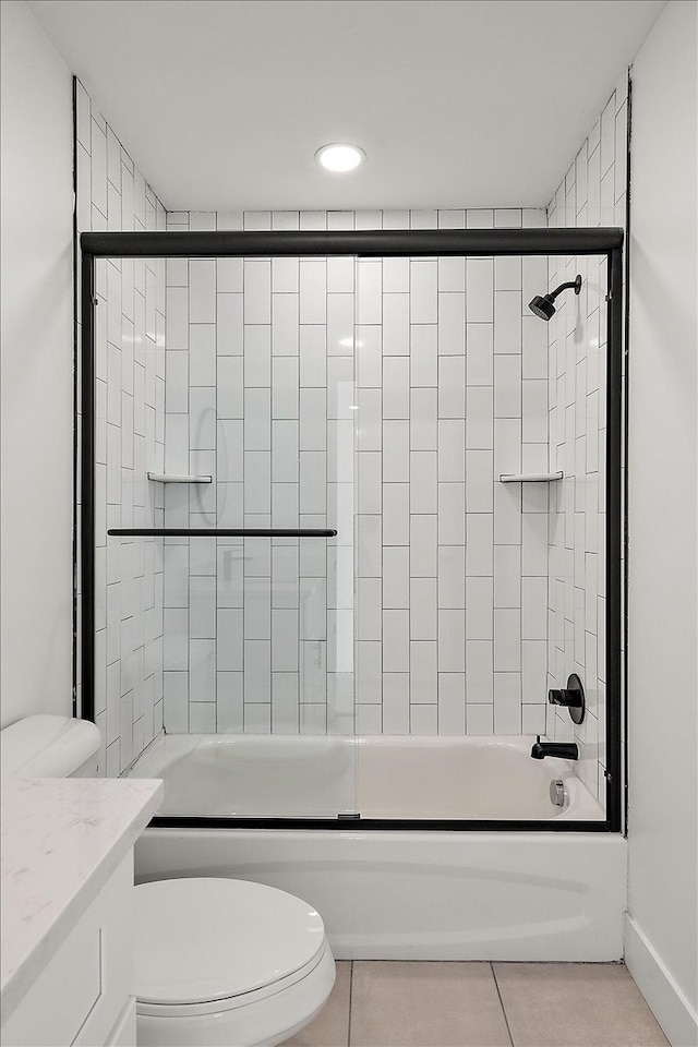 full bathroom featuring vanity, toilet, combined bath / shower with glass door, and tile patterned flooring