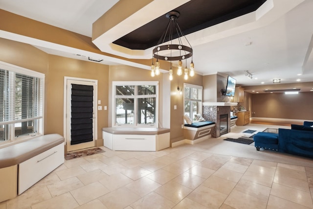372 Overlook Dr, Oxford, MI 48371 - interior space with a glass covered fireplace, tile patterned floors, baseboards, and a notable chandelier