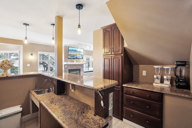 372 Overlook Dr, Oxford, MI 48371 - kitchen with a tile fireplace, light tile patterned floors, light stone counters, and a sink