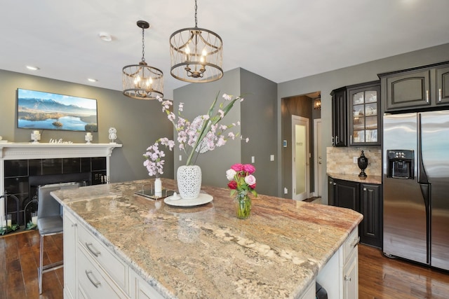 372 Overlook Dr, Oxford, MI 48371 - kitchen with stainless steel fridge with ice dispenser, a notable chandelier, light stone countertops, and dark wood-style flooring