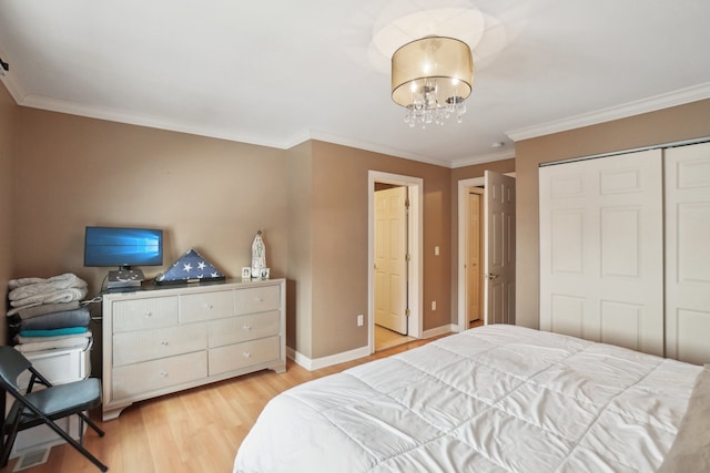 372 Overlook Dr, Oxford, MI 48371 - bedroom with light wood-type flooring, baseboards, an inviting chandelier, a closet, and ornamental molding