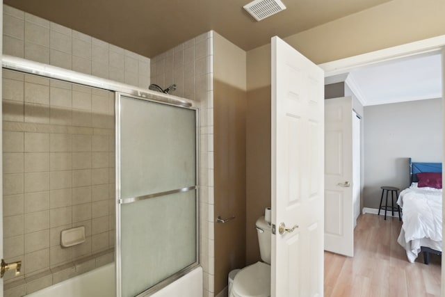 372 Overlook Dr, Oxford, MI 48371 - full bath with shower / bath combination with glass door, toilet, visible vents, wood finished floors, and connected bathroom