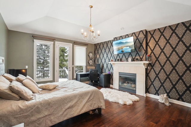 372 Overlook Dr, Oxford, MI 48371 - bedroom featuring baseboards, an inviting chandelier, an accent wall, hardwood / wood-style flooring, and a fireplace