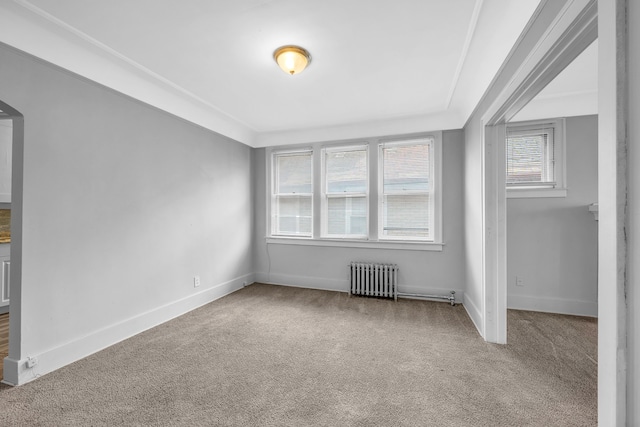 carpeted spare room featuring radiator heating unit