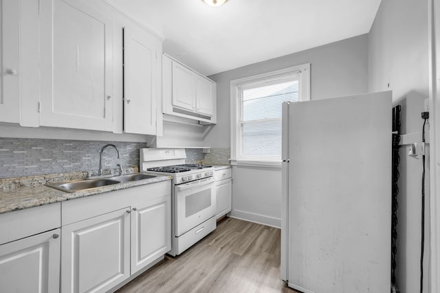 kitchen with sink, white appliances, light hardwood / wood-style flooring, white cabinetry, and decorative backsplash