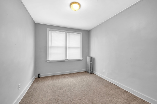 carpeted empty room with radiator heating unit and ornamental molding