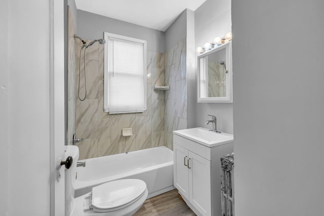 full bathroom featuring vanity, tiled shower / bath combo, wood-type flooring, and toilet