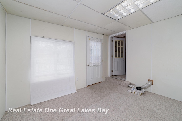 empty room featuring a drop ceiling and carpet