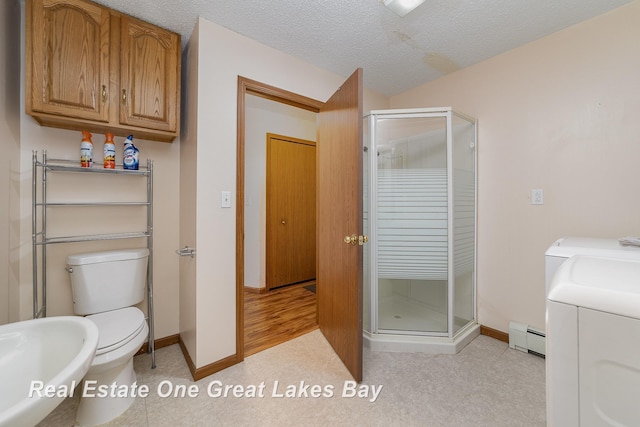 bathroom with a baseboard radiator, separate washer and dryer, a textured ceiling, and an enclosed shower