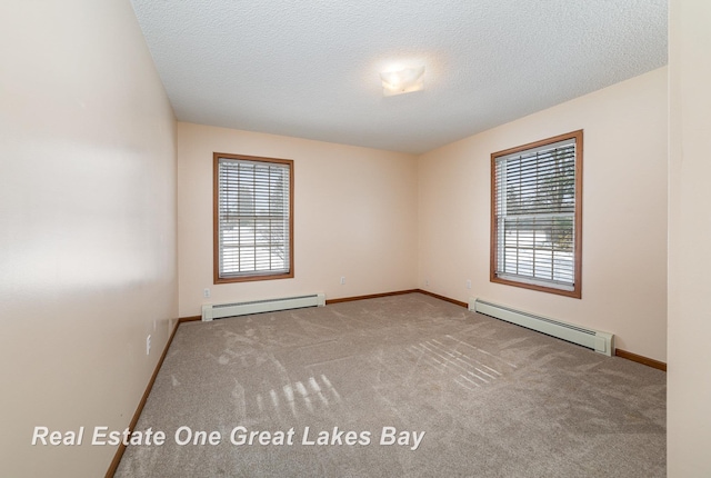 carpeted empty room featuring baseboard heating and a textured ceiling